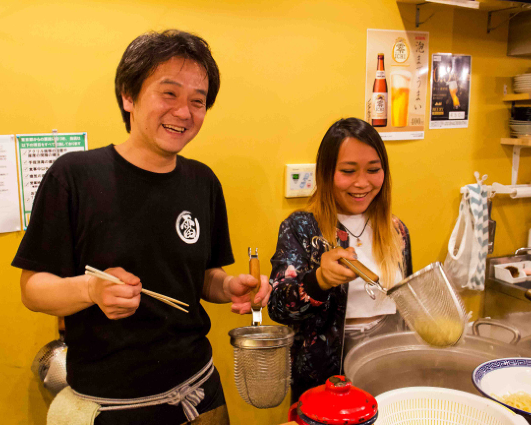 ラーメン店の厨房で麺の湯切りを体験